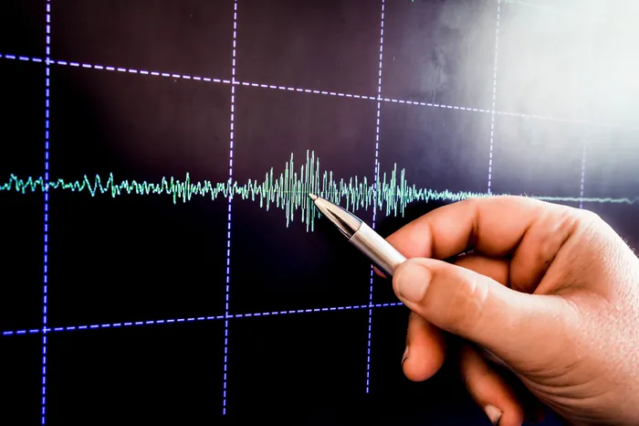 Hand som pekar på en vibrationskurva på en mätskärm